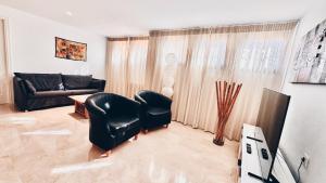 sala de estar con silla negra y sofá en VillaCarajo La Herradura, en La Herradura