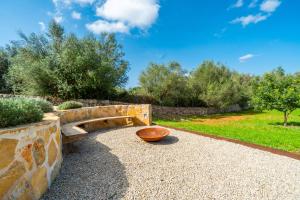 a stone bench in a garden with a bowl at Finca Casa BINITAREF in Sineu