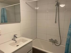 ein Badezimmer mit Waschbecken und Dusche in der Unterkunft Strandparel 381 in Breskens