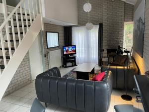 ein Wohnzimmer mit Sofa und Fernseher in der Unterkunft Strandparel 381 in Breskens