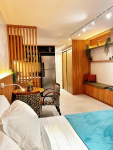a bedroom with a bed and a desk and a table at Estúdio sofisticado no centro do Rio com vaga de garagem in Rio de Janeiro