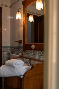 a bathroom with a sink and a mirror and towels at Casa los toriles in Ortigosa del Monte