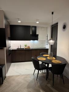 a kitchen and dining room with a table and chairs at Modern Vero Apartments Portova in Gdynia