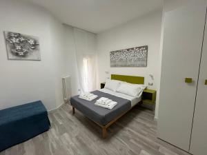 a white bedroom with a bed and a chair at Prospettiva Medina in Naples