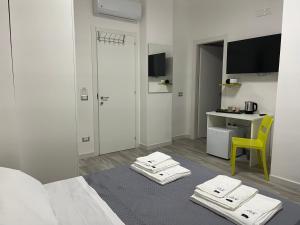 a room with a bed with a table and a yellow chair at Prospettiva Medina in Naples