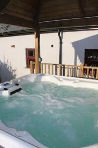 wanna z hydromasażem z niebieską wodą w domu w obiekcie Broadway Farm Holiday Barn with hot tub w mieście Swansea