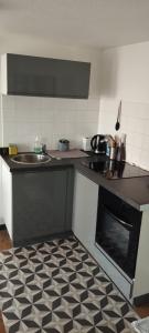 a kitchen with a black and white tile floor at Appartement F2 in Vandoncourt