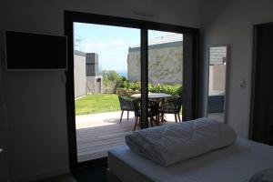sypialnia z drzwiami prowadzącymi na patio ze stołem w obiekcie Ty Dag - Petite Terre vue mer, spa, plage à 300m w mieście Roscoff