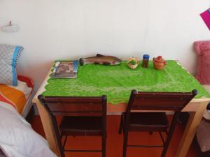 a table with two chairs and a toy fish on it at Uros Titicaca coila lodge in Puno
