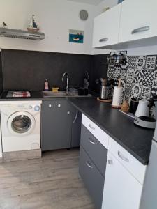 une cuisine avec une machine à laver et un lave-linge dans l'établissement Studio 2 personnes proche des plages et commerces, à La Seyne-sur-Mer