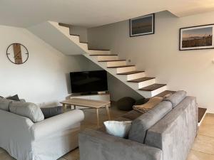 a living room with a couch and a staircase at Sète, Villa Clara maison 5 étoiles avec piscine in Sète