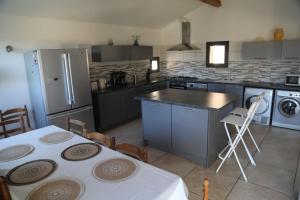 a kitchen with a table and a kitchen with appliances at Sète, Villa Clara maison 5 étoiles avec piscine in Sète