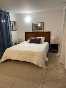 a bedroom with a large white bed with two lamps at Sète, Villa Clara maison 5 étoiles avec piscine in Sète
