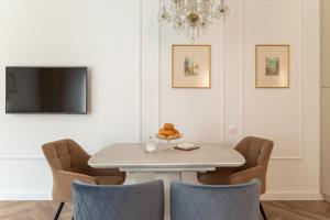 a dining room with a white table and chairs at "M&D ApartmentsLviv" Ultra Lux Rynok Square, 6person in Lviv