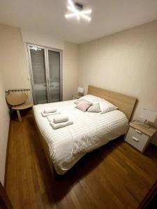 una camera da letto con un letto con due asciugamani sopra di Sète, grande villa familiale avec Jacuzzi a Sète