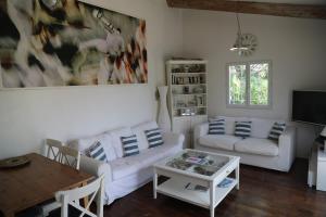 ein Wohnzimmer mit zwei weißen Sofas und einem Tisch in der Unterkunft Sète - Villa près de l'étang de Thau in Saint-Joseph