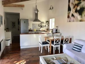 eine Küche und ein Wohnzimmer mit Tisch und Stühlen in der Unterkunft Sète - Villa près de l'étang de Thau in Saint-Joseph