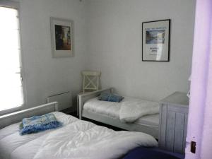 ein Schlafzimmer mit zwei Betten und einem Tisch und einem Fenster in der Unterkunft Sète - Villa près de l'étang de Thau in Saint-Joseph