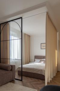 a bedroom with a bed and a couch and a mirror at "M&D ApartmentsLviv" Ultra Lux Rynok Square, 6person in Lviv