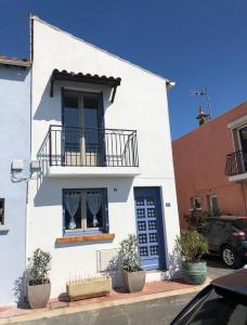 - un bâtiment blanc avec un balcon et une fenêtre dans l'établissement Petit nid coquet à la Pointe Courte, à Sète