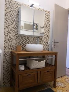 une salle de bains avec un lavabo et un miroir dans l'établissement Petit nid coquet à la Pointe Courte, à Sète
