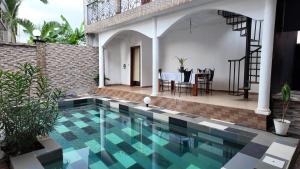 a villa with a swimming pool and a house at residence Musango la paix in Douala