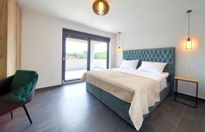 a bedroom with a bed and a chair and a window at Elegant Villa Chiara with pool in Krk +62 photos