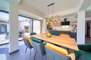 a kitchen and dining room with a wooden table and chairs at Elegant Villa Chiara with pool in Krk