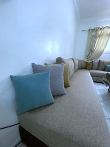 a couch sitting in a living room with pillows at Terrasseplage appartement N9 in Tamraght Ouzdar +19 photos