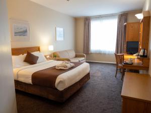 a hotel room with a large bed and a desk at Future Inn Plymouth in Plymouth