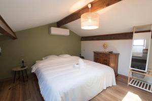 a bedroom with a large white bed and a television at Fé Di Biou - Jardin Parking Clim in Arles +15 photos