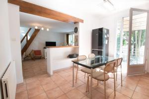 a dining room with a glass table and chairs at Fé Di Biou - Jardin Parking Clim in Arles