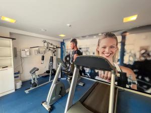 a woman on a treadmill in a gym at Flats Vista Mar PontaNegra in Natal