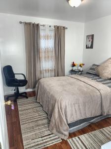 a bedroom with a bed and a chair in it at Fada Guest House - 38 Yates Ave Newark in Newark