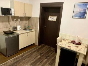 a small kitchen with a sink and a door at Alex Lodge in Zrenjanin