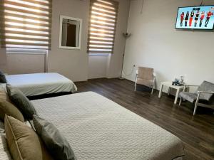 a bedroom with two beds and a table and chairs at Alex Lodge in Zrenjanin