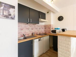 a kitchen with black cabinets and a sink at Peyragudes : Appart 8 pers, balcon, parking, wifi - FR-1-695-51 in Germ