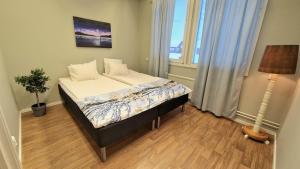 a bedroom with a bed and a lamp in it at Kuttainen Lodge in Karesuando