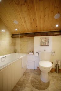 a bathroom with a toilet and a bath tub at The Old Town Hall in Redmire +28 photos