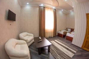 a living room with two chairs and a table at Olympic Hotel Gyumri in Gyumri