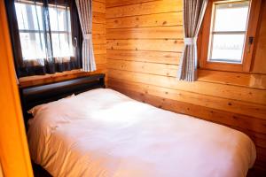 Postel nebo postele na pokoji v ubytování Three Peaks Log スリーピークス ログ
