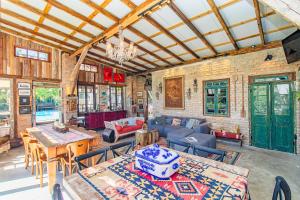 a large living room with tables and chairs at Vieja Hacienda in Praia do Rosa
