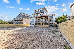 a large house on the beach with a fence at Marianne’s in Avon