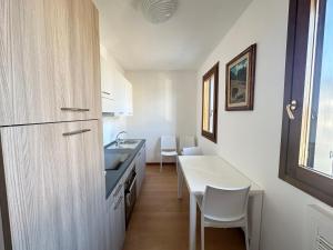 a kitchen with a sink and a table and chairs at Appartamento Marisa in San Vendemiano