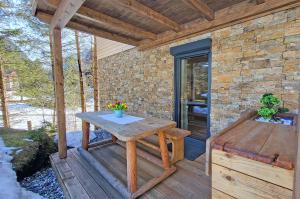 a wooden deck with a wooden table and a bench at Almliesl GAST-719 in Bad Gastein