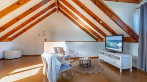 a living room with a tv and a chair at Bali Huts Escape in Nowra