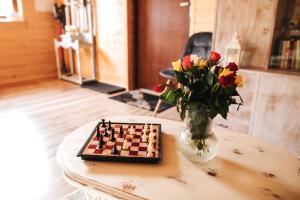 a chess board and a vase with flowers on a table at Chatka mojego dziadka in Stronie Śląskie