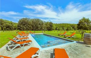a swimming pool with orange chairs and a barrel at Beautiful Home In Sauzet in Sauzet +30 photos