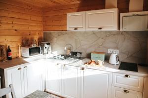 ストロニエ・シロンスキエにあるChatka mojego dziadkaのキッチン(白いキャビネット、白い電化製品付)