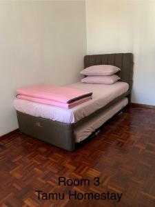 a bedroom with a bed with pink sheets and pillows at Tamu Homestay 4 islam in Sungai Petani